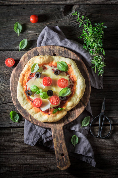 Homemade pizza with cheese, tomatoes and herbs - Foto, Bild