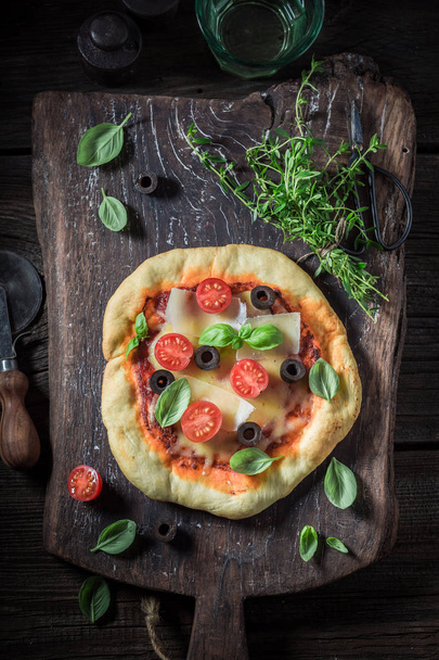 Tasty pizza made of cheese, tomatoes and olives - Foto, Bild