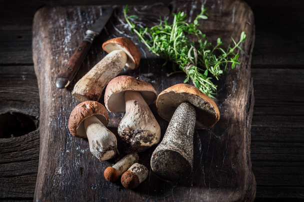 Wild mushrooms and herbs on the old board - Fotografie, Obrázek