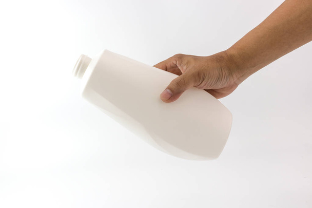 Witte plastic fles met spiraal op bovenste mond in de hand van de mens geïsoleerd op een witte achtergrond, Hand van de mens is iets uit de fles gieten. - Foto, afbeelding