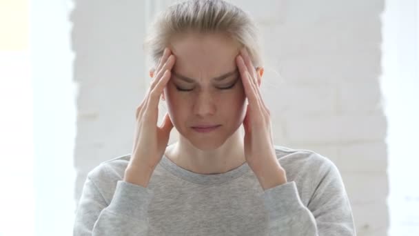 Kopfschmerzen, angespannte junge Frau bei der Arbeit im Büro, Bibliothek - Filmmaterial, Video