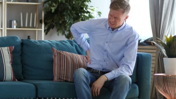 Чоловік середнього віку з болем спини сидить на дивані
 - Кадри, відео