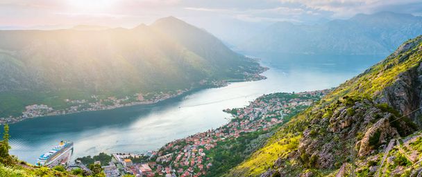 Panorámás kilátás felülről a régi város Kotor, öböl Adriai-tenger és a hegyek Montenegróban a naplemente idő, gyönyörű természet táj. - Fotó, kép