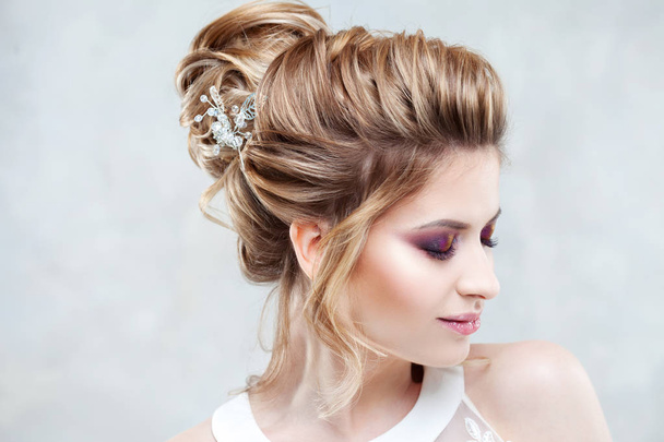 Wedding style. Beautiful young bride with luxury wedding hairstyle - Fotografie, Obrázek