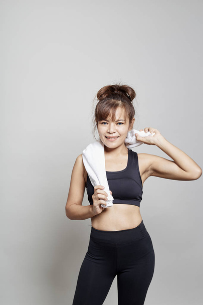 Sport asian woman holding towel around her neck on white background - Foto, Imagem