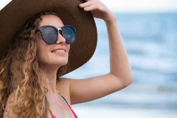 Ευτυχισμένος νεαρή γυναίκα που φοράει μαγιό έχοντας καλή στιγμή στην τροπική παραλία το καλοκαίρι για διακοπές ταξίδια διακοπές. - Φωτογραφία, εικόνα