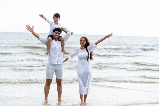 Onnellinen perhe isä, äiti ja lapset menee loma trooppisella hiekkarannalla kesällä
. - Valokuva, kuva