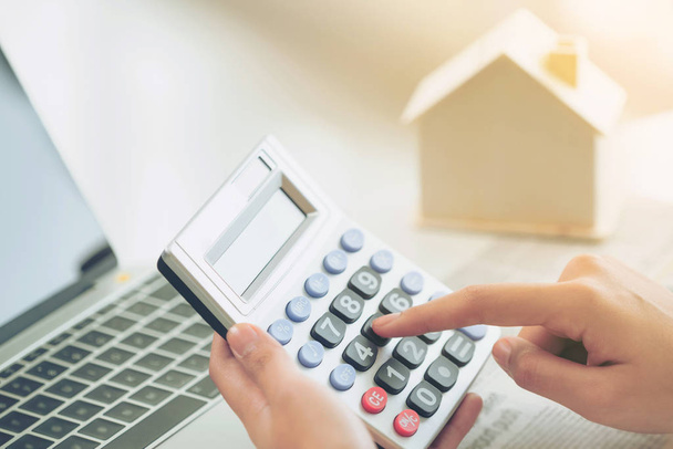 Žena účetní nebo bankovní pracovník používá Kalkulačka v kanceláři k výpočtu domu úvěr úvěrová byrokracie. - Fotografie, Obrázek