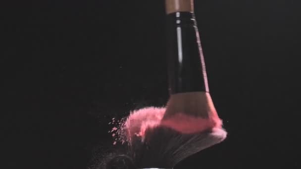 Two Make-up brushes with pink powder on a black background - Video, Çekim