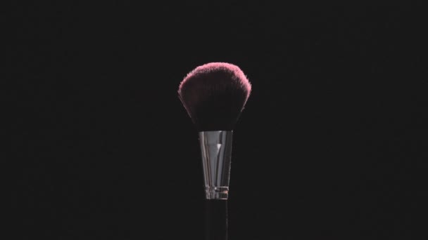 Two Make-up brushes with pink powder on a black background - Filmagem, Vídeo