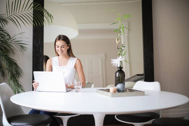 Young woman sitting in an elegant interior and working on a laptop. - Foto, immagini