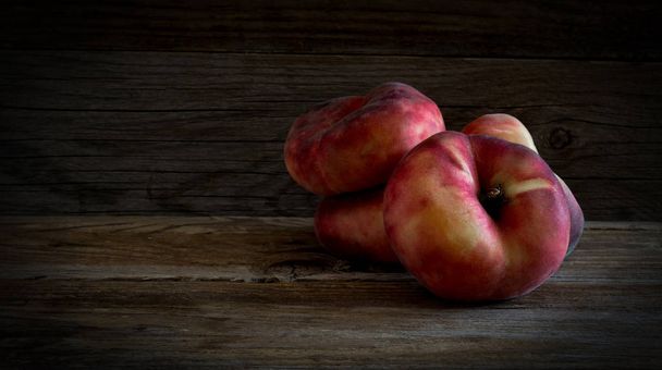 Donut Peaches chamado snuffbox ou pêssegos Saturno em mesa de madeira rústica
. - Foto, Imagem