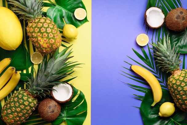 Exotic pineapples, coconuts, banana, melon, lemon, tropical palm and green monstera leaves on yellow, violet background with copyspace. Creative layout. Monochrome summer concept. Flat lay, top view. - Photo, image