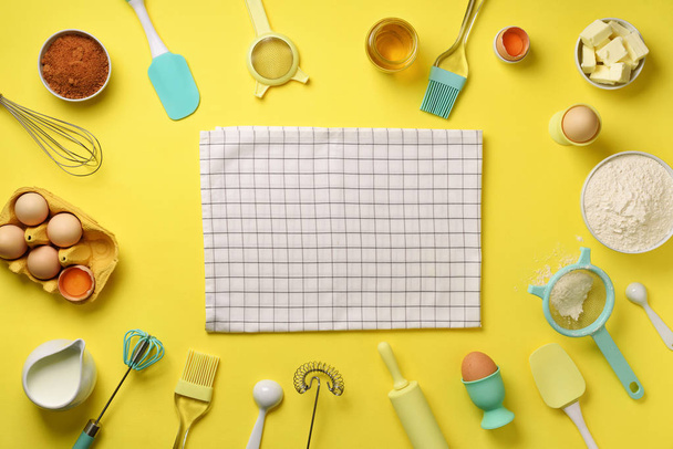Healthy baking ingredients - butter, sugar, flour, eggs, oil, spoon, rolling pin, brush, whisk, towel over yellow background. Bakery food frame, cooking concept. Top view, copy space. Flat lay - Fotó, kép