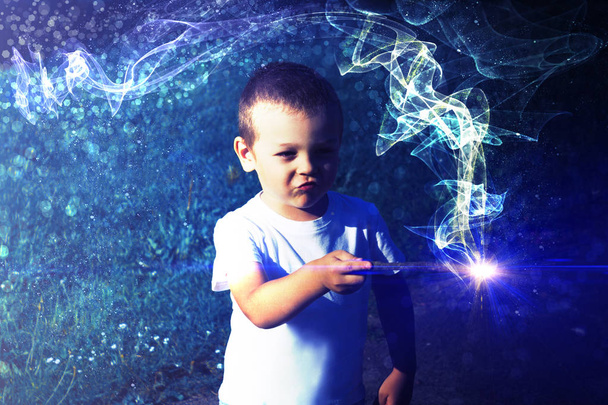 Junge mit Zauberstab in der Hand zeigt Fokus. Magischer Glanz und Taschenlampe - Foto, Bild