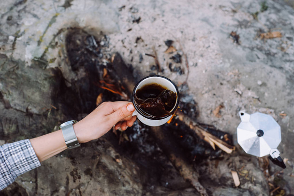 coffee the outdoors. Adventure, travel, tourism and camping concept. Hiker drinking tea from mug at camp - Foto, immagini