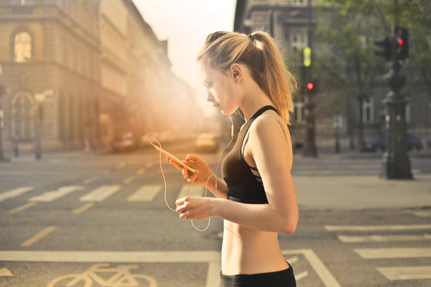 Young blonde woman jogging in the city. - Fotó, kép