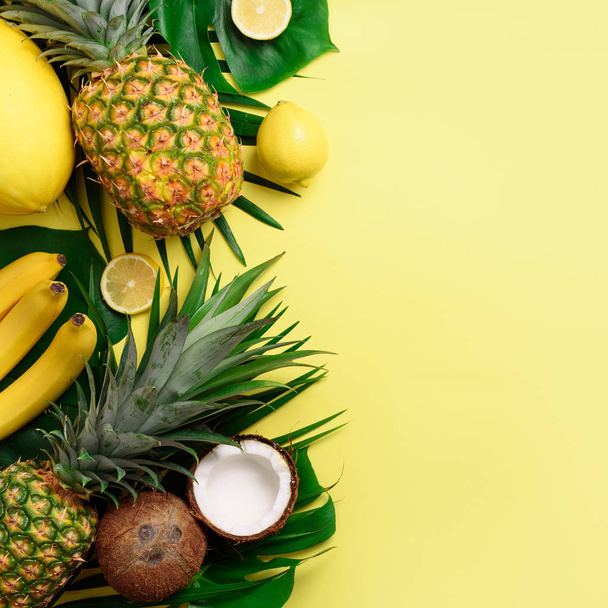 Exotic pineapples, coconuts, banana, melon, lemon, palm and monstera leaves on yellow, violet background with copyspace. Square crop. Creative layout. Monochrome summer concept. Flat lay, top view. - Fotografie, Obrázek
