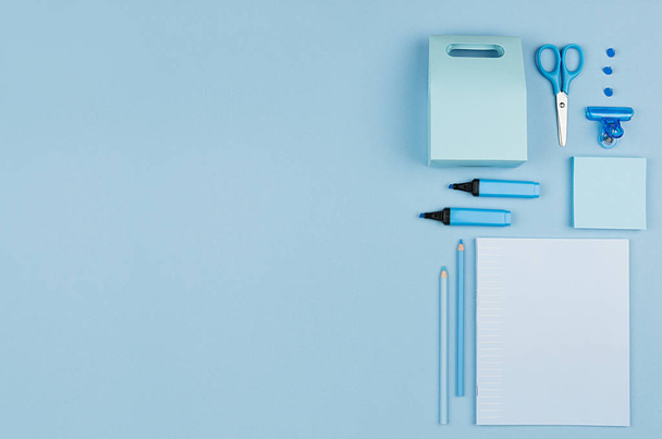 Modern youth workplace - neon blue stationery as decorative border on blue background, top view. - Foto, afbeelding
