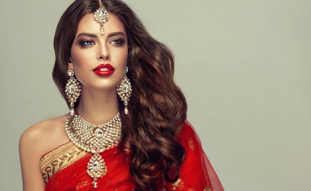 Retrato de moda bonita menina indiana. Jovem modelo hindu mulher em jóias Kundan. Traje indiano tradicional, sari vermelho
 . - Foto, Imagem