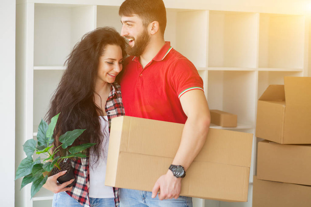 Feliz pareja joven desempacar o empacar cajas y mudarse a un nuevo hogar
 - Foto, imagen