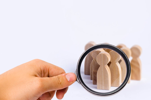 People stand in the formation of the pins. A game of bouwling. Wooden figures of persons, on a white background. The concept of business management personnel and the achievement of goals. - Photo, image