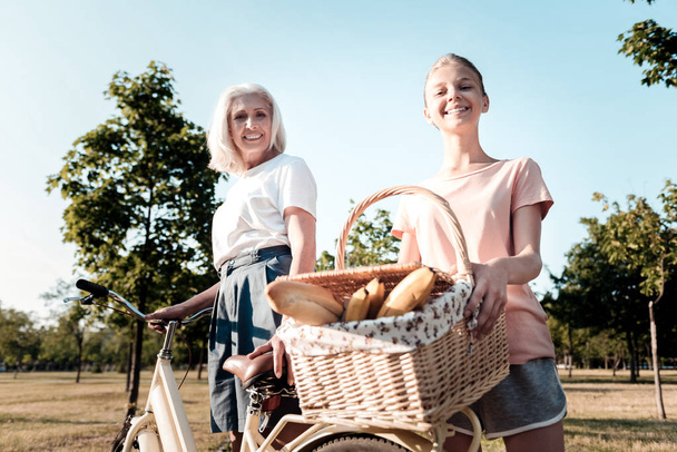 Positive delighted teenager holding big basket - Photo, Image