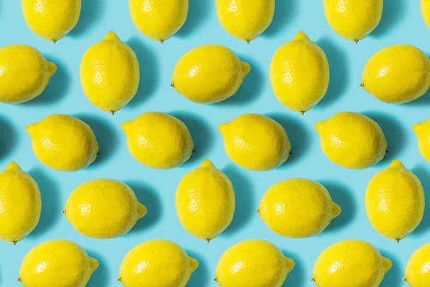 Draufsicht auf frische Zitrone isoliert auf blauem Hintergrund. Fruchtminimalkonzept. flache Lage. - Foto, Bild
