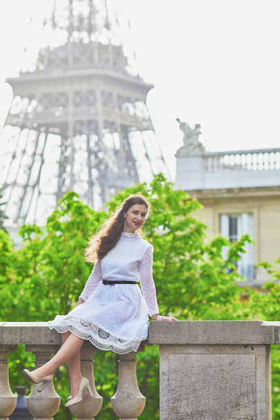 Happy young woman in white dress near the Eiffel tower in Paris, France - Zdjęcie, obraz
