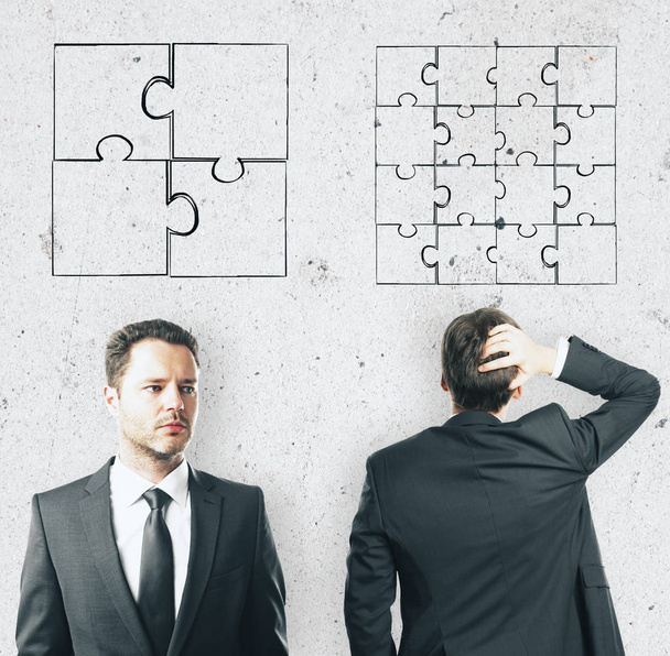 concept de discrimination avec deux hommes d'affaires et des pièces de puzzle sur le mur léger
 - Photo, image
