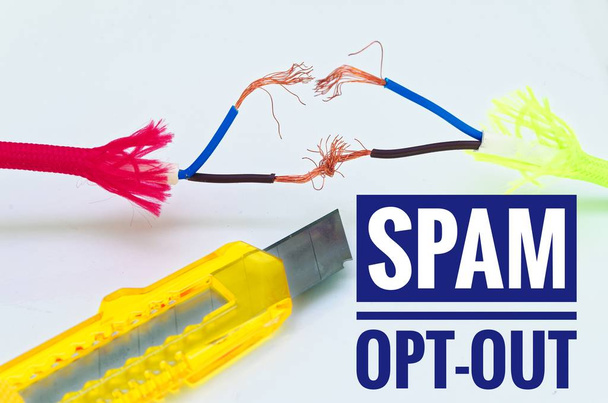 Bunte Kabel, die einzeln und provisorisch geflickt wurden und ein Bastelmesser mit der Aufschrift "Spam-Opt-out" - Foto, Bild