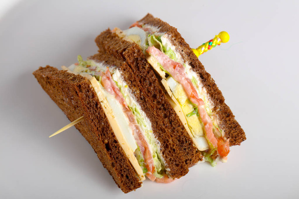 Sanduíche de clube com carne, queijo e legumes
 - Foto, Imagem