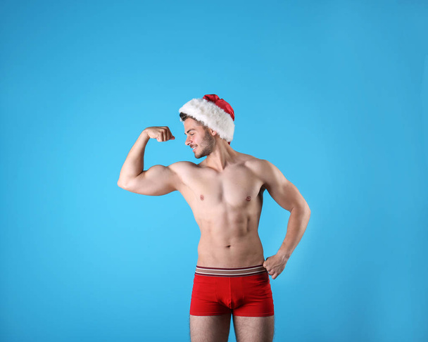 Shirtless young Santa Claus with sexy body on color background - Φωτογραφία, εικόνα