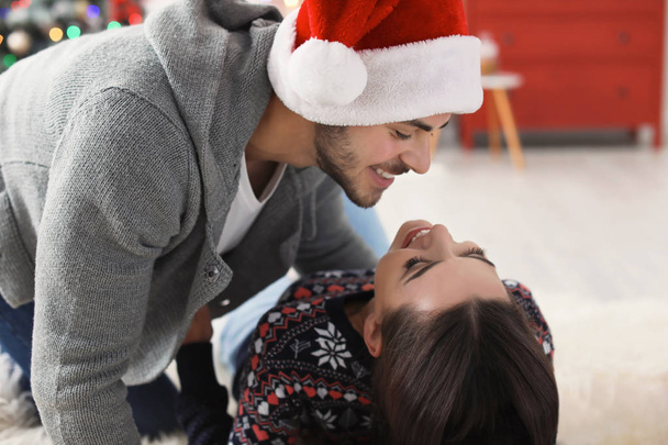 Happy young couple celebrating Christmas at home - Foto, imagen