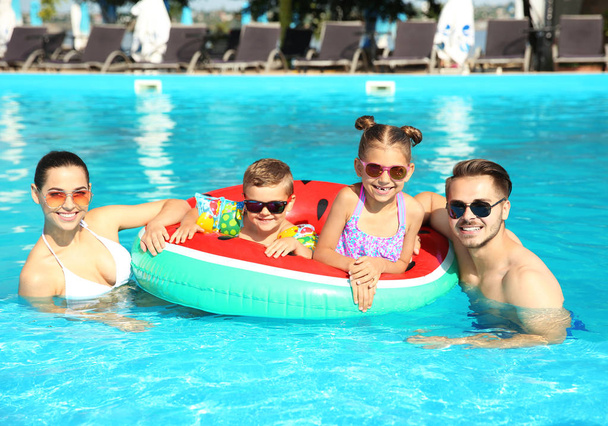 Young family with little children in swimming pool on sunny day - Fotoğraf, Görsel