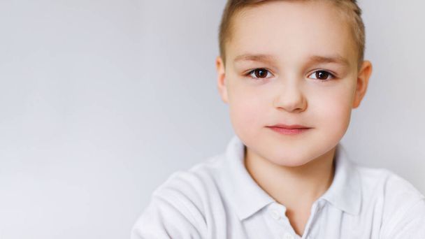 Portrait of a young boy of caucasian against a white wall. - Zdjęcie, obraz