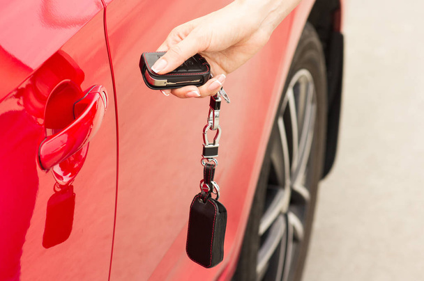 Female hand opens the door of a red car - Photo, Image