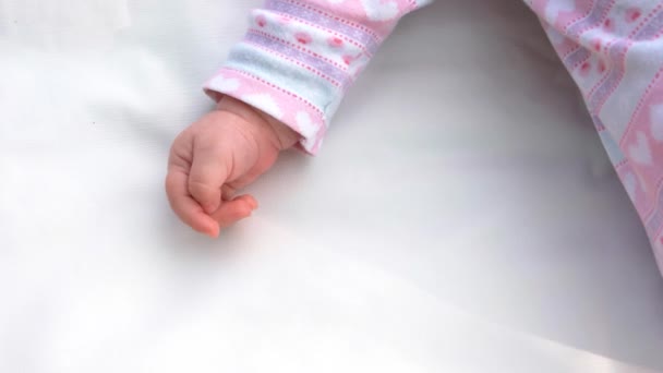 Hand van pasgeboren meisje op witte tapijt. - Video