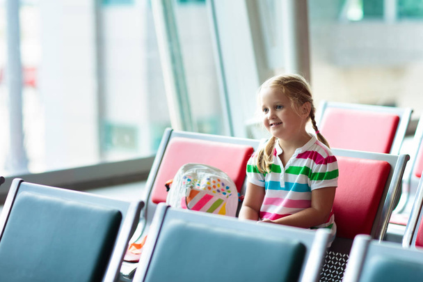 Gyerekek repülőtéren. Gyermekek Nézd meg repülőgép. Utazás és a gyermek. Indulási kapu család. Nyaralás és utazás a fiatal gyerek. Kislány repülés terminál előtt. Gyerekek légy a sík. - Fotó, kép