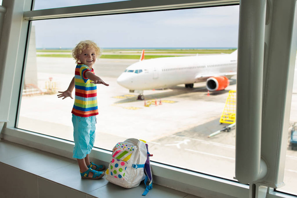 Kids at airport. Children look at airplane. Traveling and flying with child. Family at departure gate. Vacation and travel with young kid. Little boy before flight in terminal. Kids fly a plane. - Photo, Image