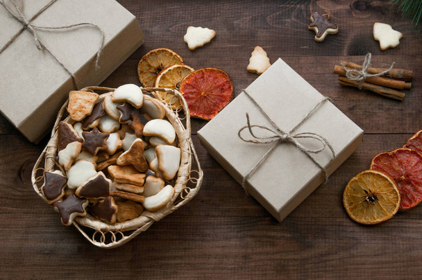 Vue du dessus du fond de Noël. Cadeaux de Noël, biscuits et oranges sèches sur une table en bois marron.
. - Photo, image