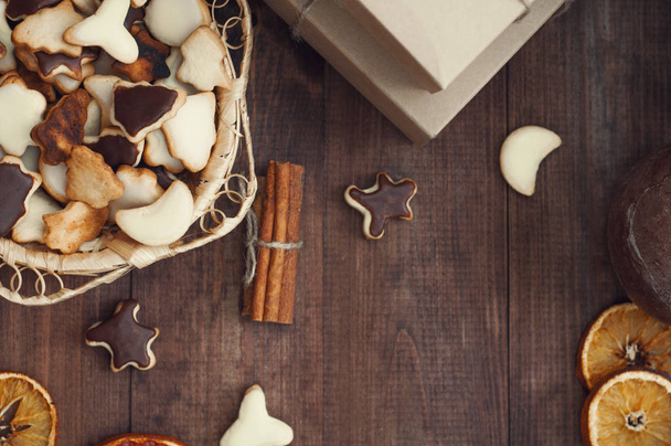 Widok z góry Boże Narodzenie tła. Prezenty świąteczne, pliki cookie i suche pomarańcze na brązowy drewniany stół. - Zdjęcie, obraz