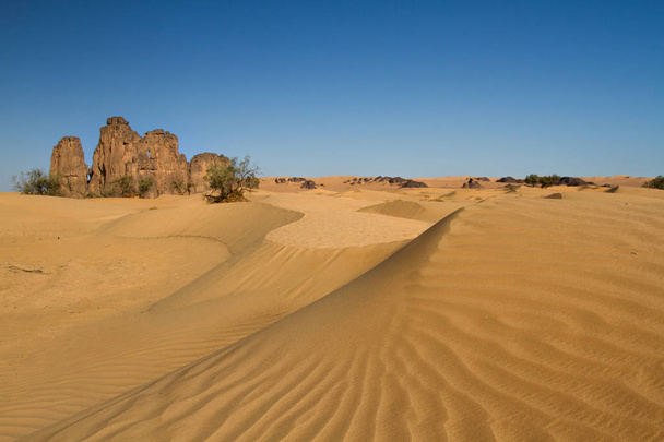 Saharas krajobraz. Niesamowite, pojedyncze formacja skalna w pobliżu Dajnet, Południowej Algierii, Afryki Północnej - Zdjęcie, obraz
