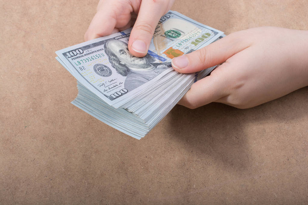 Ruční držení americké dolarové bankovky izolované na dřevěném pozadí - Fotografie, Obrázek