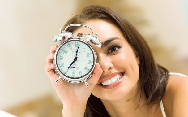Woman with alarmclock on the bed - Foto, Imagem