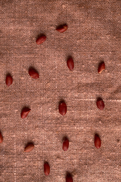 クルミ ピーナッツは荒布の背景に散在しています。揚げピーナッツ - 写真・画像