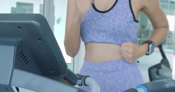 Asian girl running on the treadmill in the gym. - Felvétel, videó
