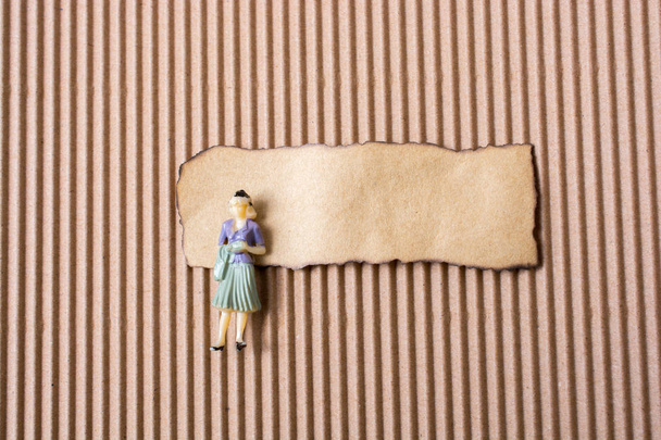 Жінка фігурка на шматку спаленого рваного паперу б
 - Фото, зображення