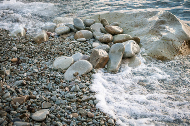 Великі камені на пляжі, змиті хвилею
 - Фото, зображення