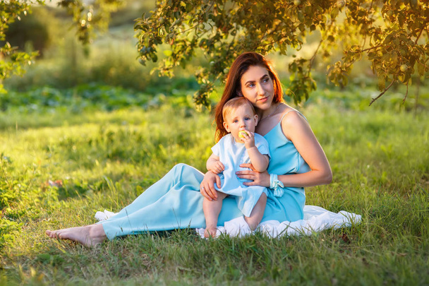 mother with little daughter playing on green grass - Photo, Image